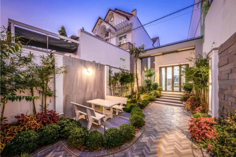 Sân vườn nhỏ trước nhà cấp 4 với bộ bàn ghế tạo không gian thư giãn mát mẻ, gần gũi thiên nhiên